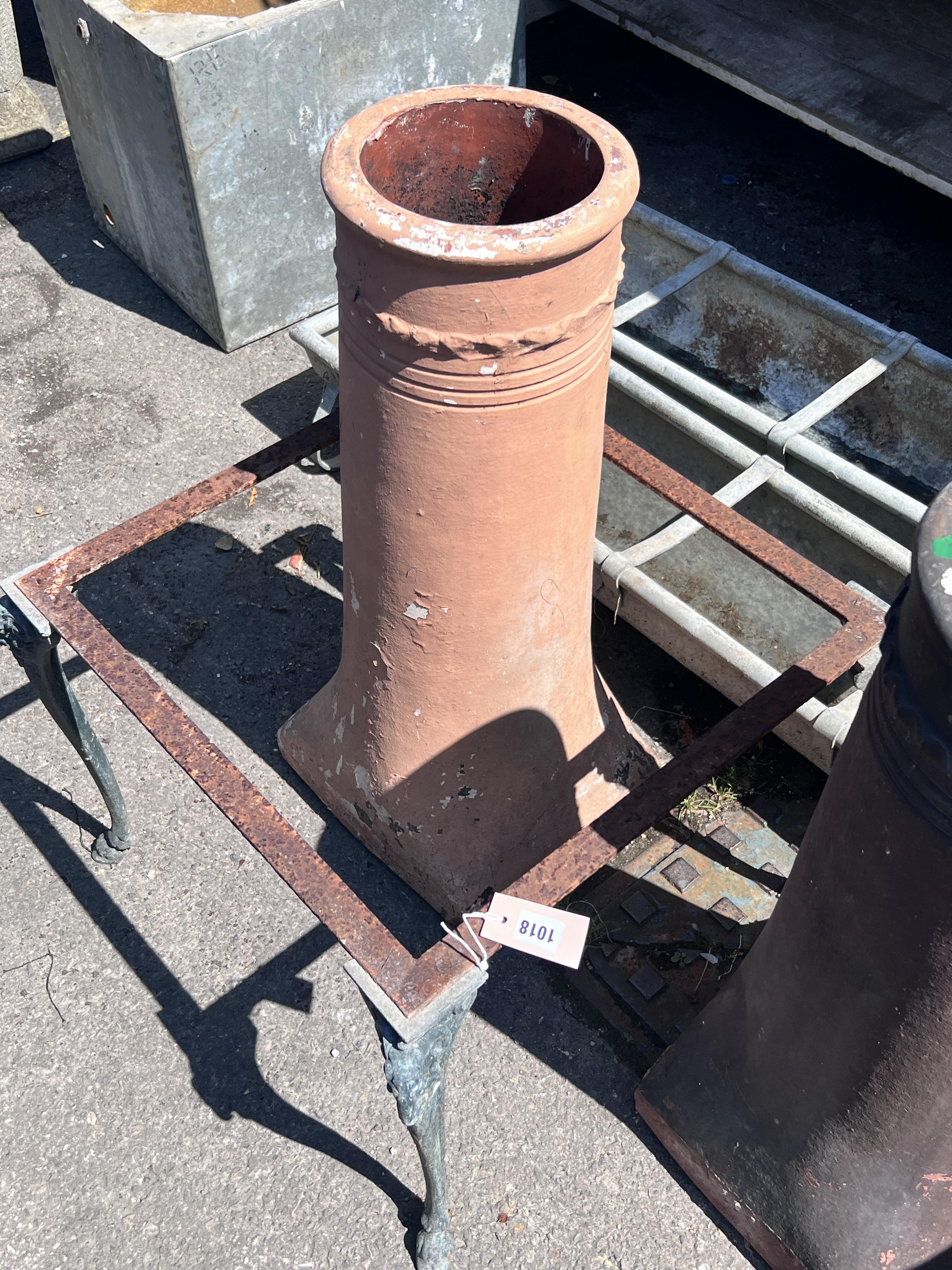 Two terracotta chimney pots, height 77cm, together with a square metal table frame